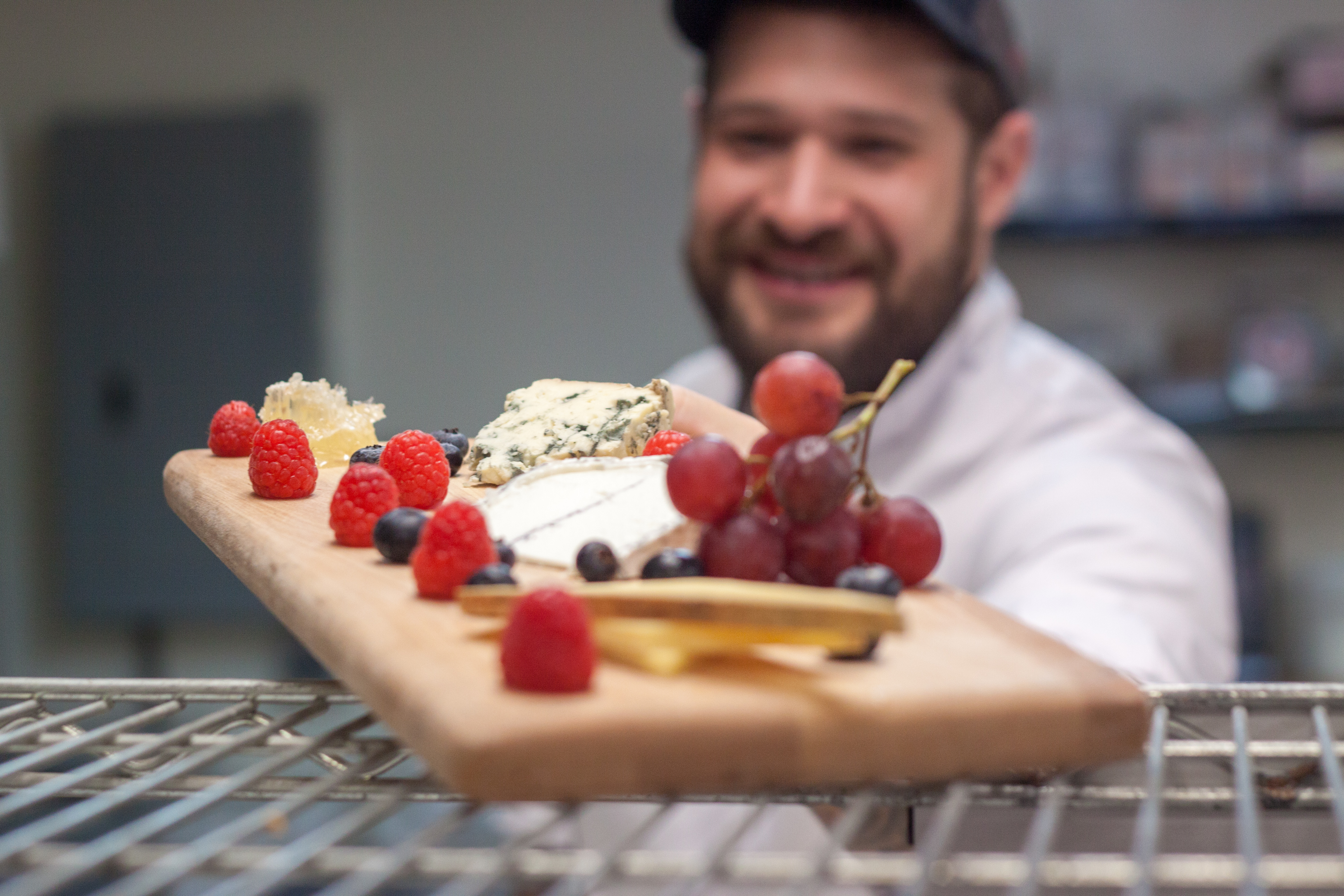 A chef presents food to be taken to a table 